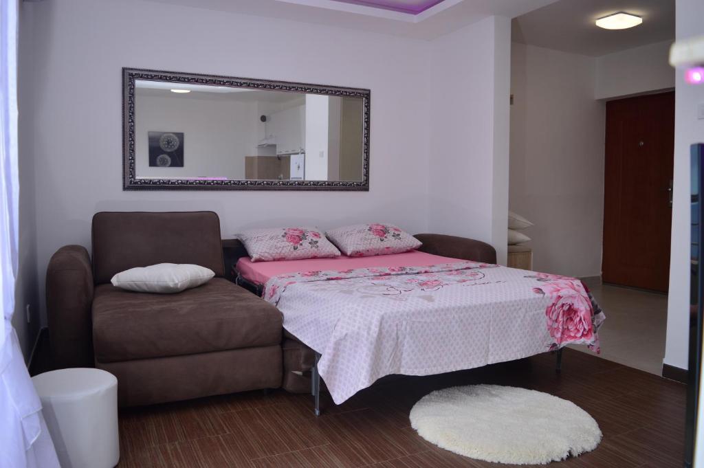 ein Schlafzimmer mit einem Bett, einem Stuhl und einem Spiegel in der Unterkunft Panorama Petrovac in Petrovac na Moru