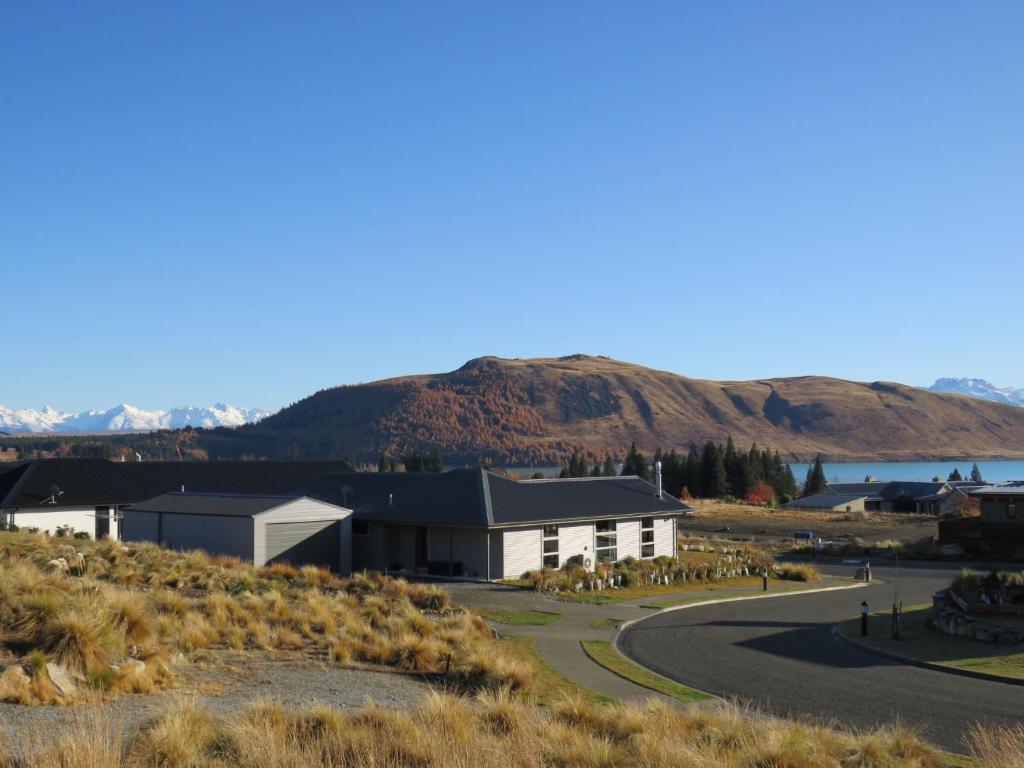 a building on a road with a mountain in the background at Majestic View - Lake Tekapo in Lake Tekapo