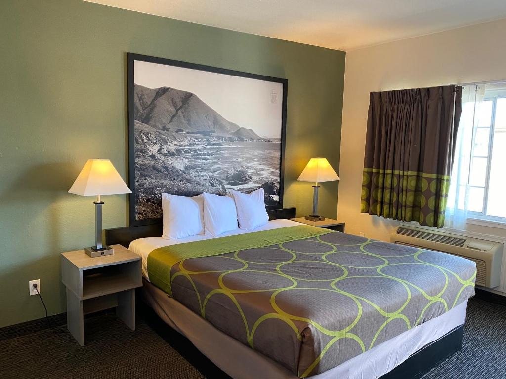 a hotel room with a bed and two lamps at Super 8 by Wyndham Monterey in Monterey