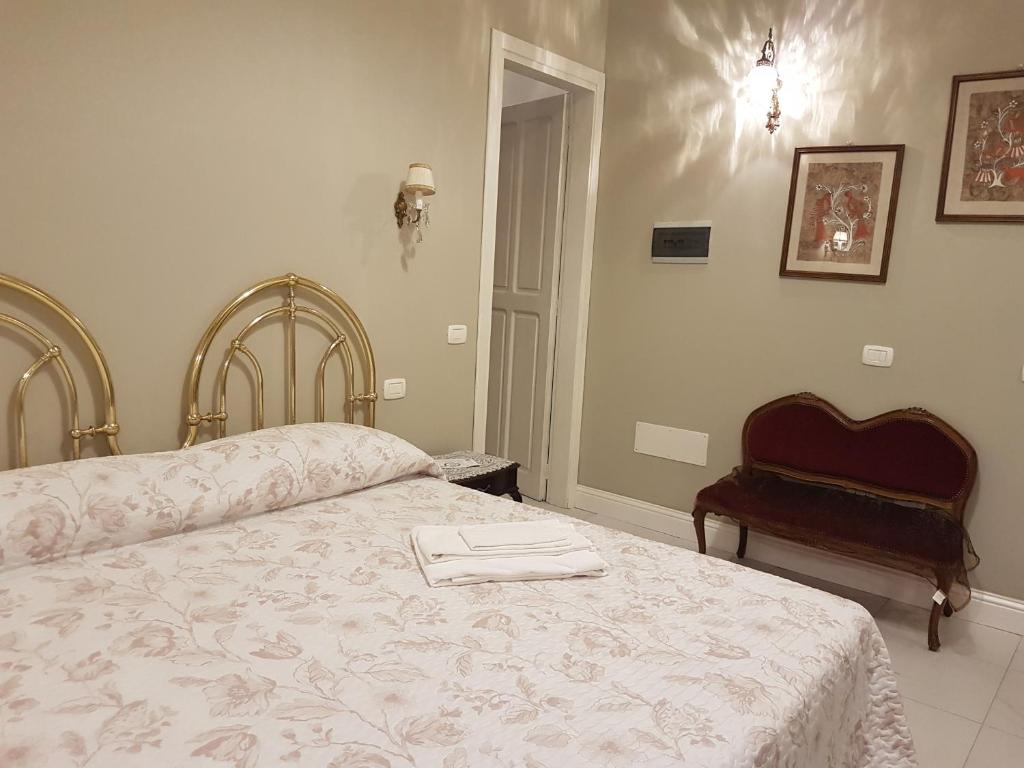 um quarto com uma cama e uma cadeira em VILLA LIBERTY OFELIA locazioni brevi em Cagliari