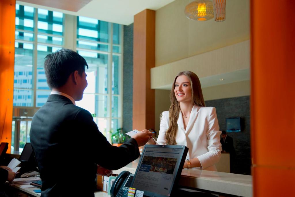 a man interviewing a woman in an office at Yas Island Rotana Abu Dhabi in Abu Dhabi
