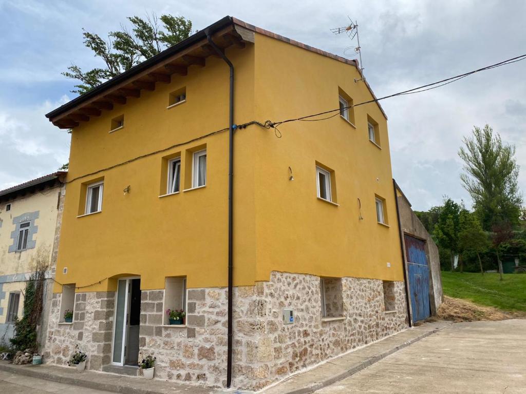 a yellow building on the side of a street at Casa Rural Aguachales in Villanueva-Matamala
