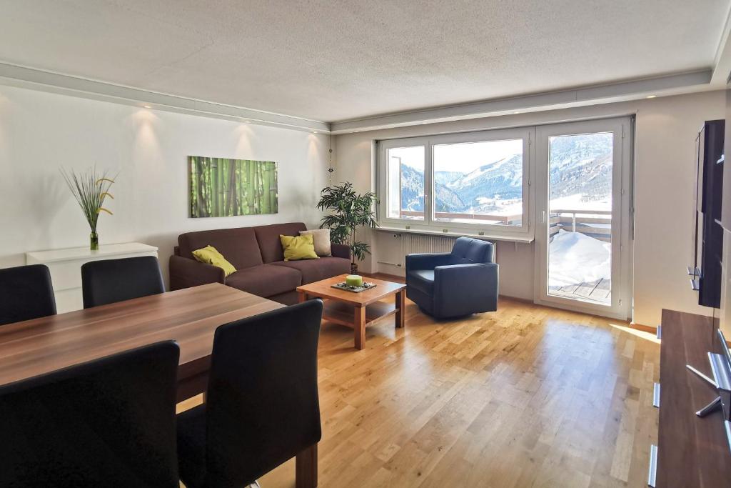 a living room with a table and a couch at Leukerbad Holiday Home in Leukerbad