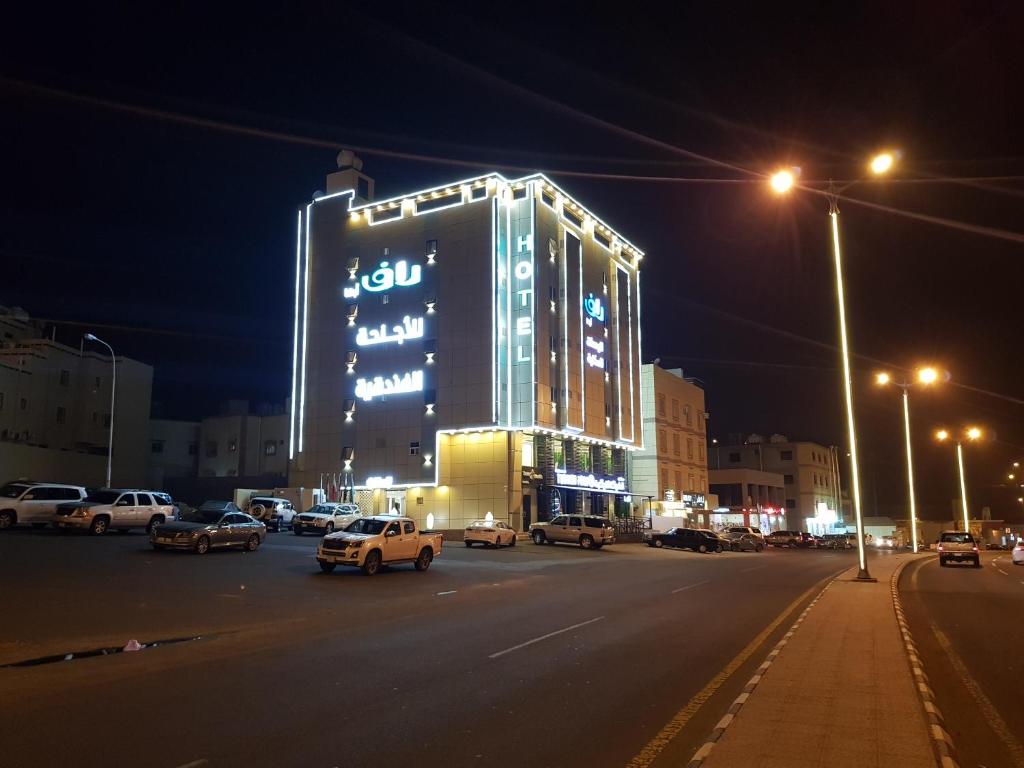 a lit up building in a city at night at RAF Furnished Hotel Suites in Abha