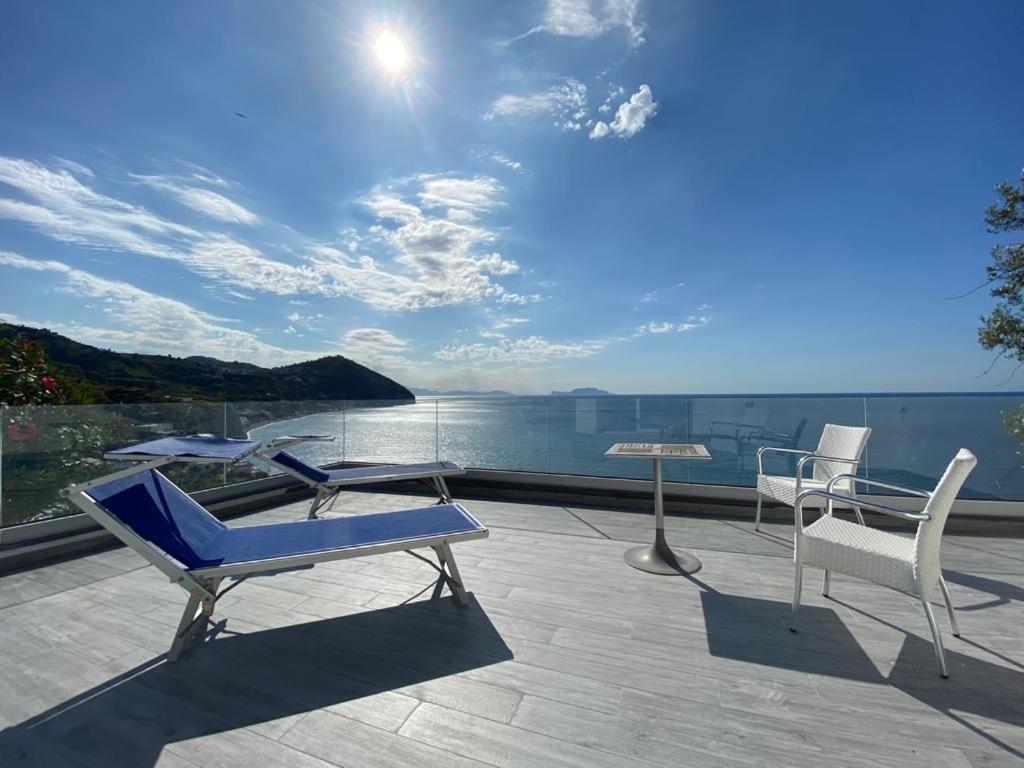 - une terrasse avec des chaises, une table et de l'eau dans l'établissement Hotel Casa Sofia, à Ischia