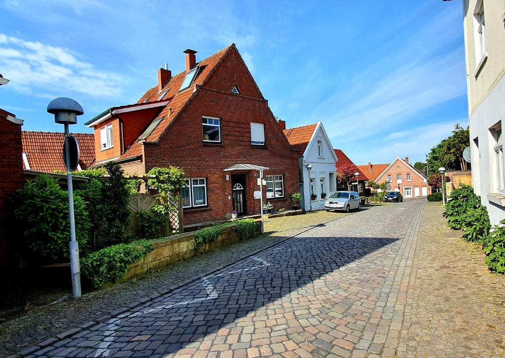 eine Kopfsteinpflasterstraße neben einem Backsteinhaus in der Unterkunft Ferienwohnungen Bentheimer Altstadt in Bad Bentheim