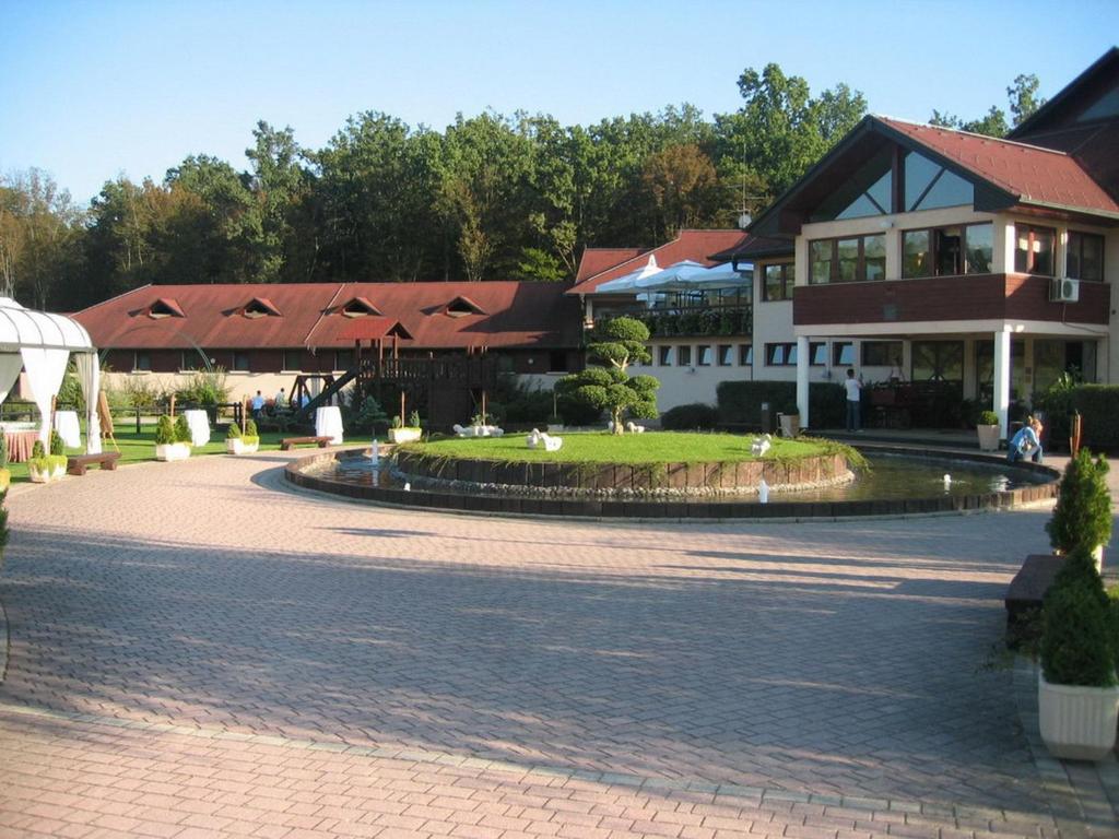 ein Gebäude mit einem Brunnen in der Mitte einer Straße in der Unterkunft Guesthouse Trajbar Team in Zaprešić