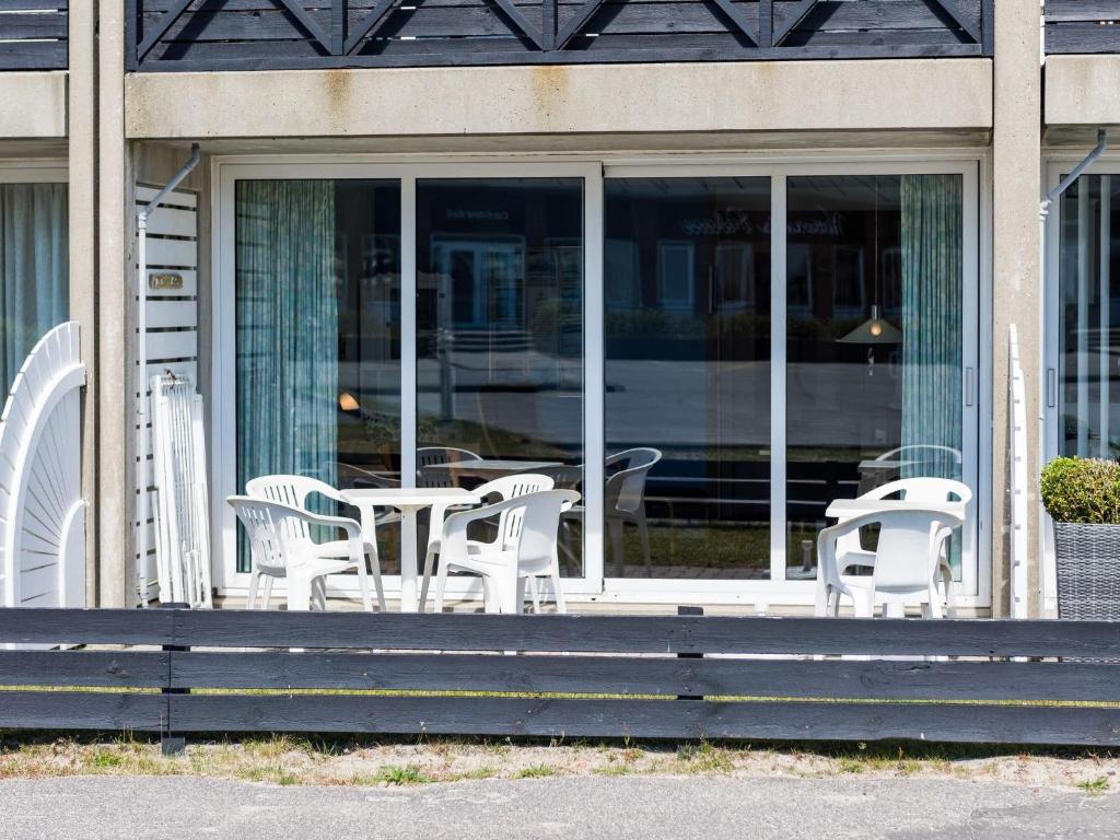 a group of chairs and tables on a porch at 4 person holiday home in Fanø in Fanø