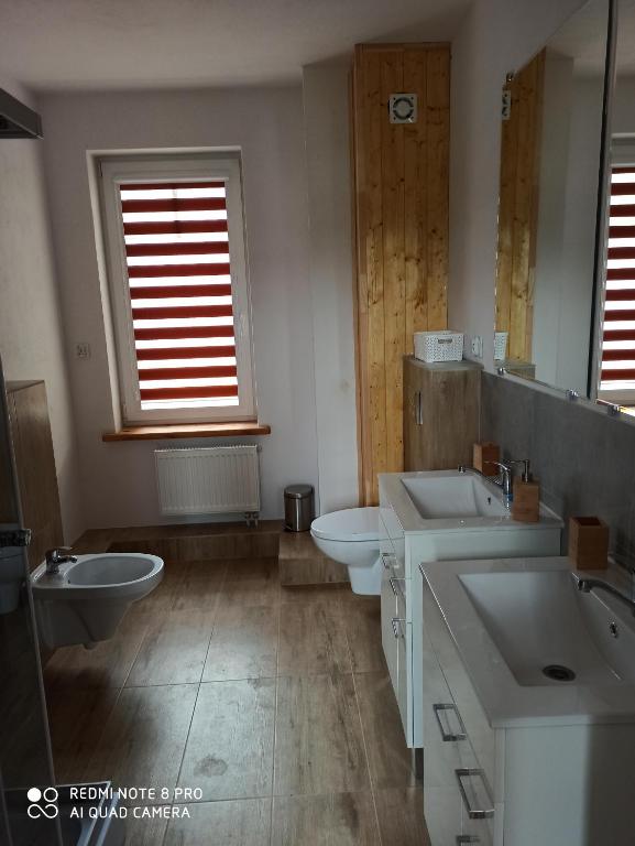 een badkamer met 2 wastafels en 2 toiletten bij Villa Hillas in Reda