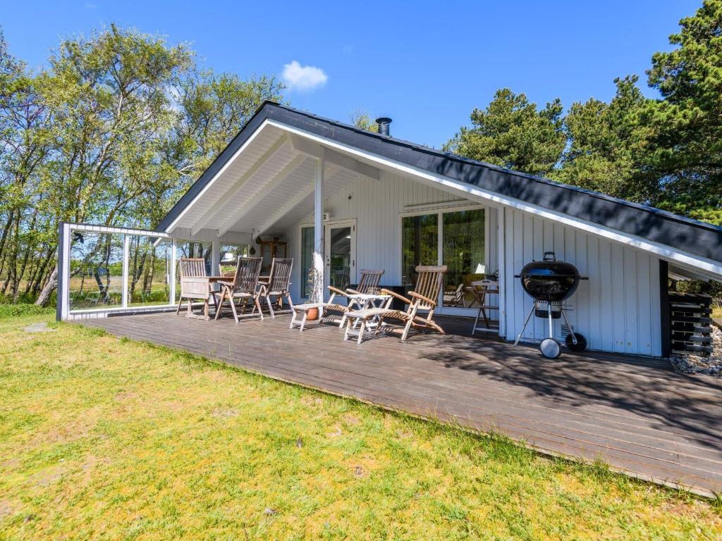ein Haus mit einer Terrasse mit Stühlen und einem Grill in der Unterkunft Holiday home Fanø LXXI in Fanø