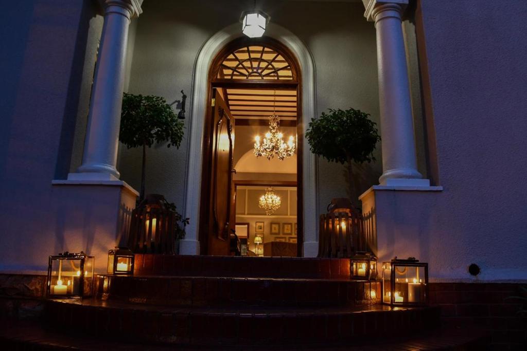 Johannesburg的住宿－The Great Gatsby Houghton，一座带楼梯的建筑和一扇带吊灯的门