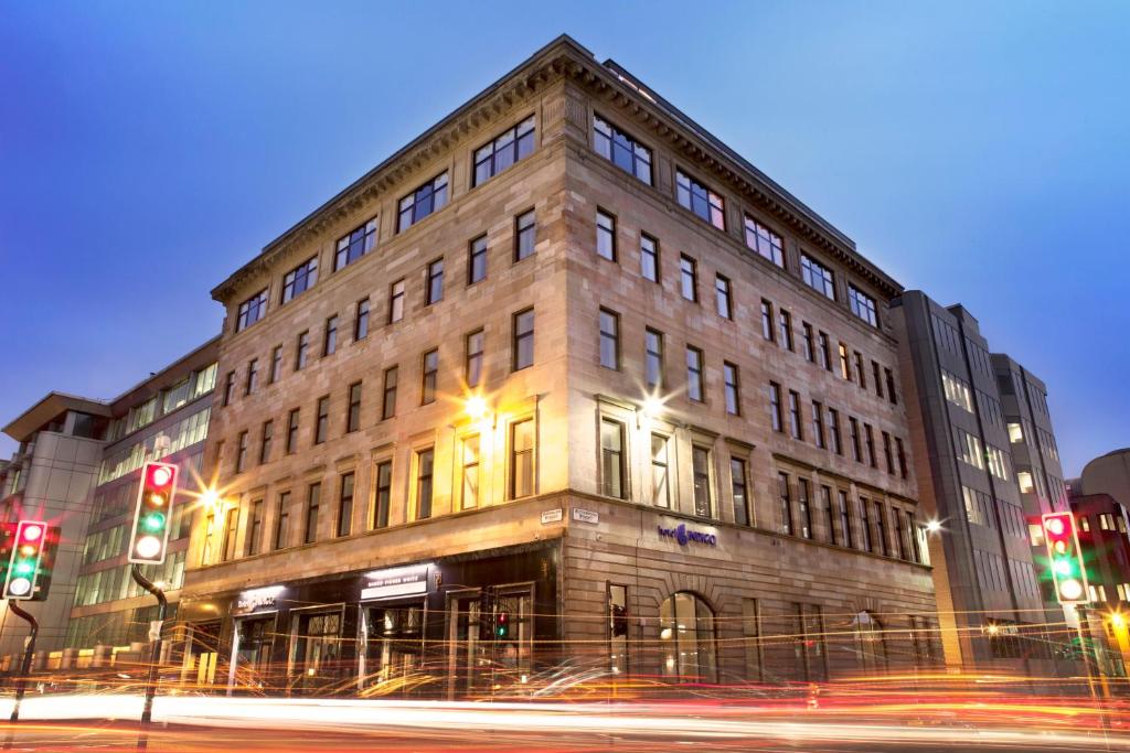 un bâtiment au coin d'une rue avec des feux de circulation dans l'établissement Hotel Indigo Glasgow, an IHG Hotel, à Glasgow