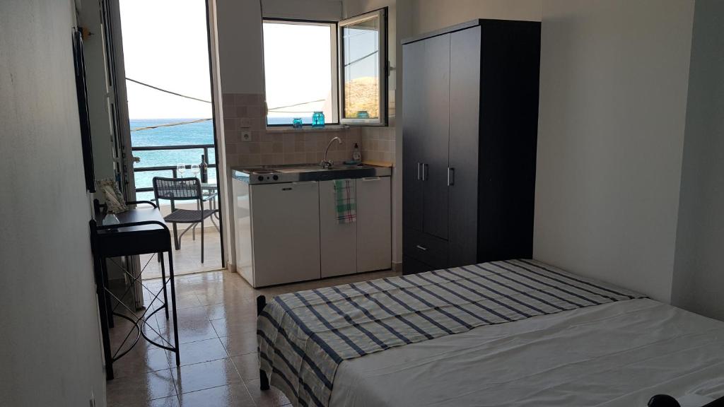 a bedroom with a bed and a kitchen with a sink at Porto Haraki Studios in Haraki