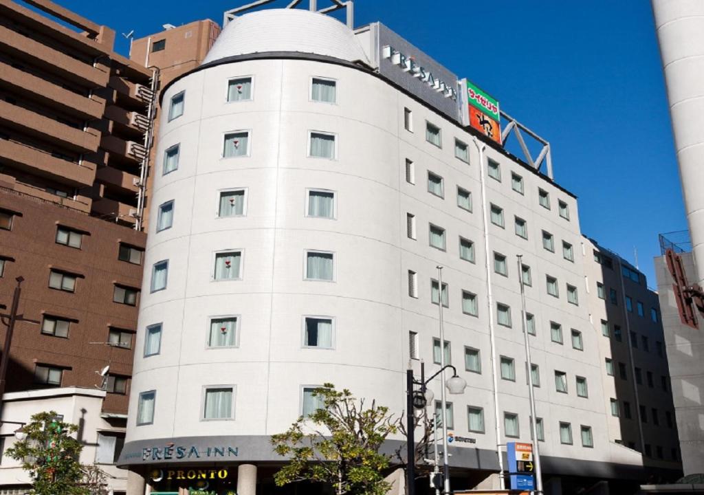 a white building with a sign on top of it at Sotetsu Fresa Inn Tokyo-Toyocho in Tokyo