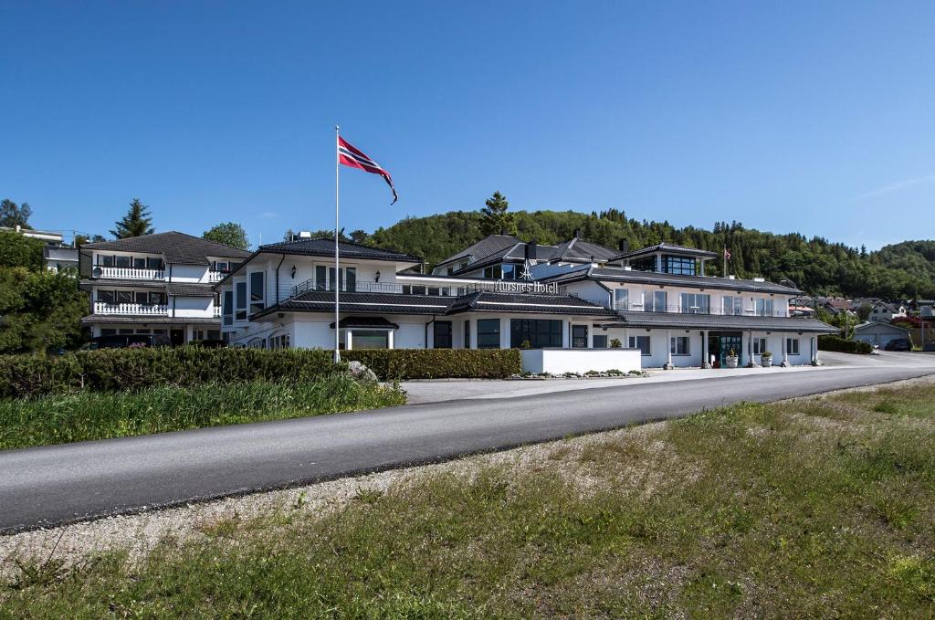 a house with a flag on the side of a road at Aursnes Hotell in Sykkylven