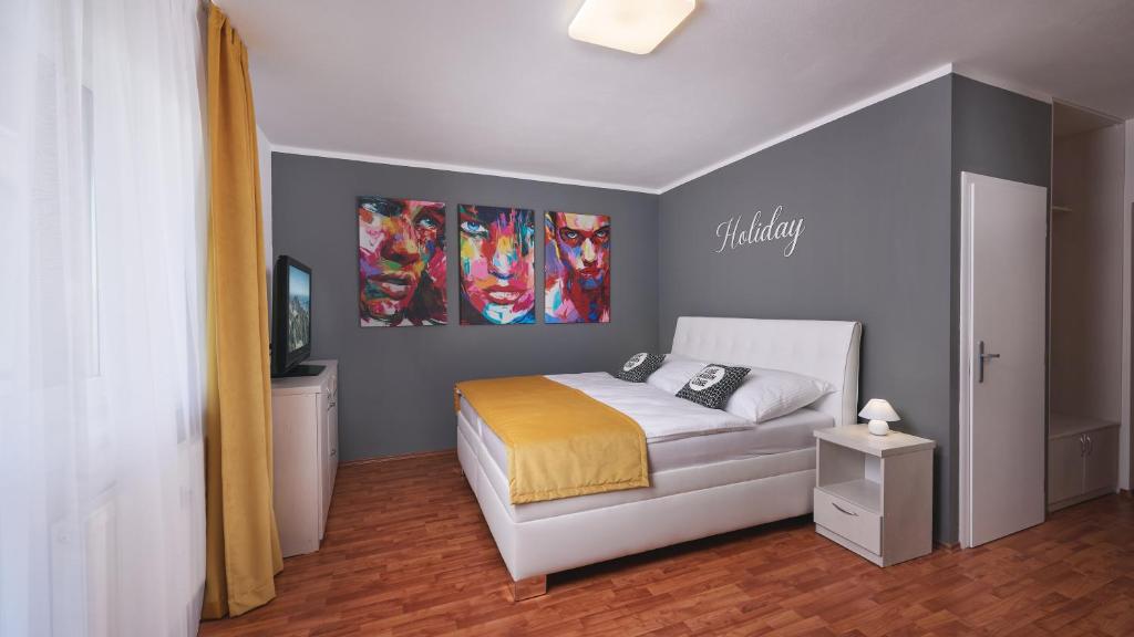- une chambre avec un lit et une télévision dans l'établissement Holiday apartment High Tatras, à Tatranská Lomnica