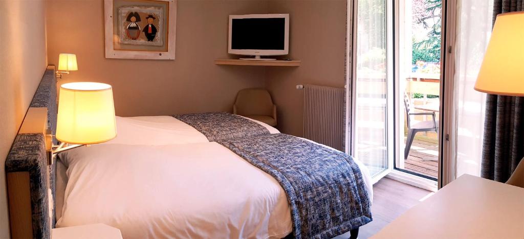 Postel nebo postele na pokoji v ubytování Hotel Les Remparts