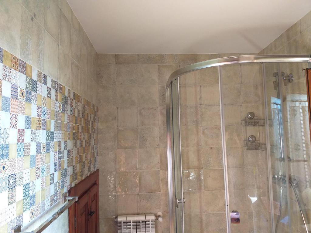 baño con ducha con azulejos en la pared en Casuca Pico Jiniro, en Abionzo