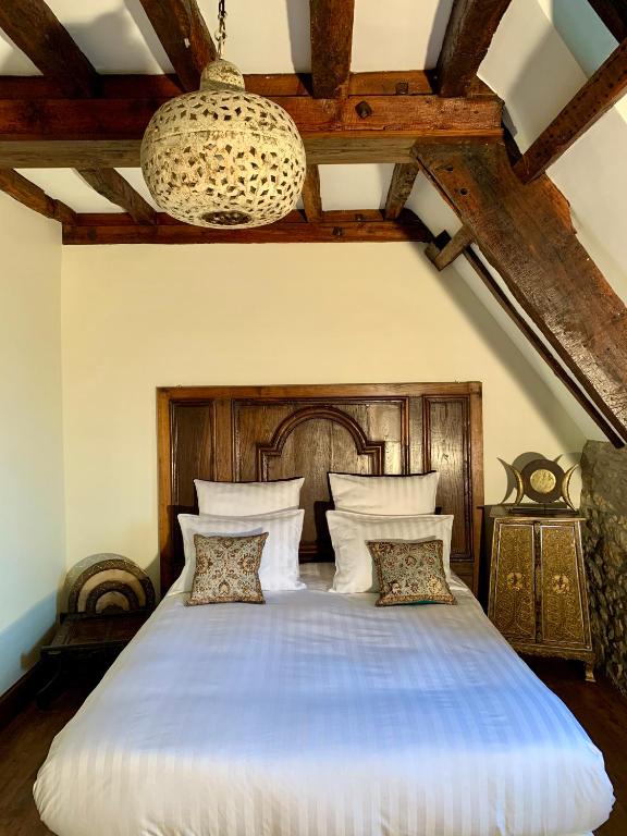 a bedroom with a large bed with a wooden headboard at LA MEFFRAIS 1741 in Dinan