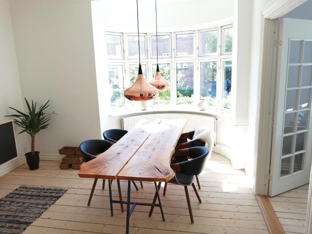 a dining room with a wooden table and chairs at Cozy Villa-Apartment - Close to Aalborg center - Free citybikes and parking in Aalborg