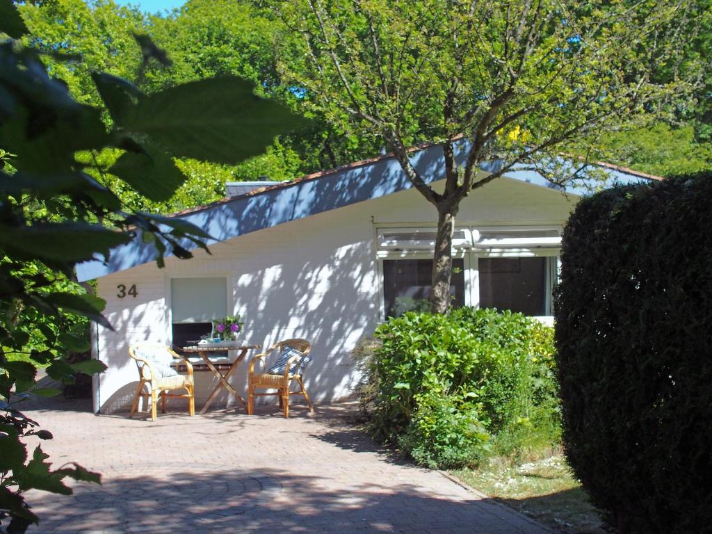 een tafel en stoelen voor een huis bij Vakantiehuis La petite Redousse in Renesse