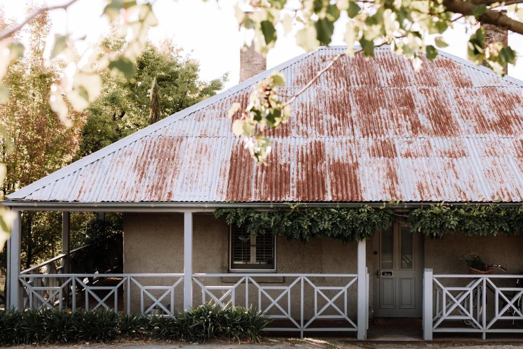 ein altes Haus mit rostigem Zinndach in der Unterkunft French Cottage Beechworth with stunning Alfresco Garden in Beechworth