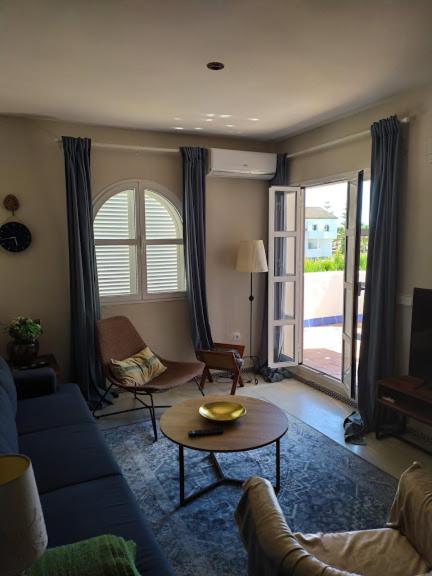 salon z niebieską kanapą i stołem w obiekcie apartamento Costa Sancti-Petri La Barrosa Chiclana w mieście Chiclana de la Frontera