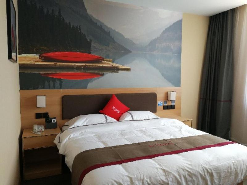 um quarto com uma cama grande e uma pintura na parede em Thank Inn Chain Hotel Changzhi Qingyang Manor em Changzhi