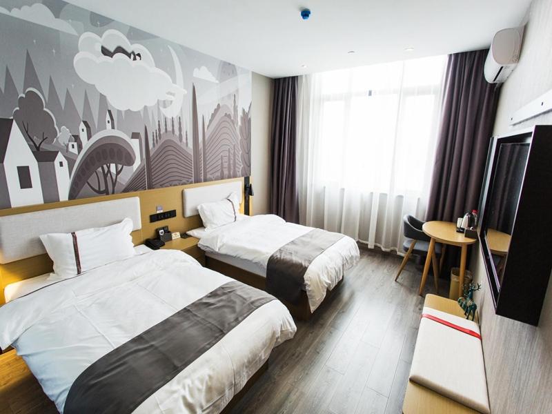 a hotel room with two beds and a tv at Thank Inn Chain Hotel Zhejiang Huzhou Deqing County Xinshi Town Huancheng West Road in Huzhou