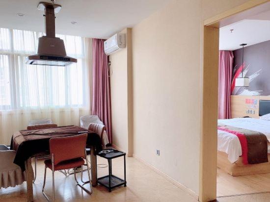 a room with a bedroom with a table and a bed at Thank Inn Chain Hotel Jiangxi Ganzhou Yudu County Railway Station Store in Ganzhou