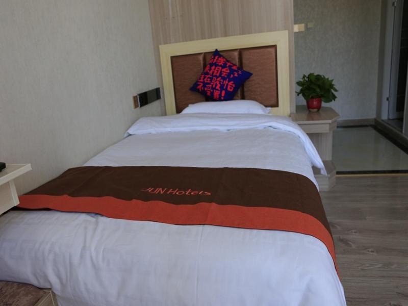 a large bed in a bedroom with at JUN Hotels Gansu Lanzhou Lanzhou New District Jing'er Road Asia-Pacific World Trade Center Square in Lanzhou