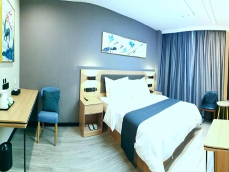 a hotel room with a bed and a desk at Thank Inn Plus Hotel Jining Qufu Confucius Museum in Jining