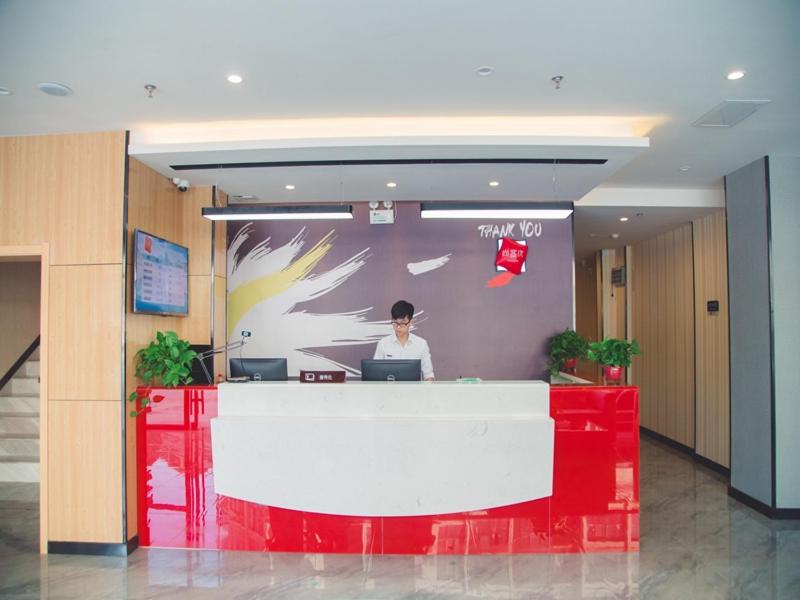 a woman sitting at a desk in an office at Thank Inn Chain Hotel Sanmenxia Wanda Plaza New Gantang Road in Sanmenxia