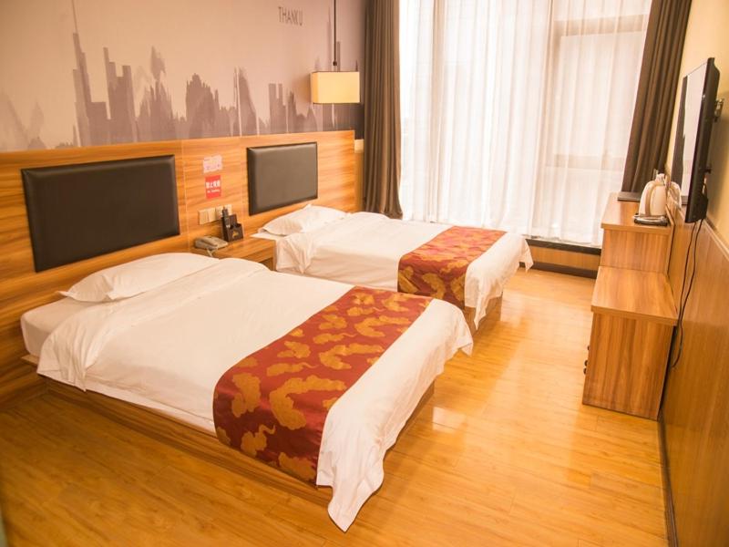 Cette chambre comprend 2 lits et une télévision à écran plat. dans l'établissement Thank Inn Chain Hotel He'nan Zhengzhou Zhengdong New District East Staiton, à Zhengzhou