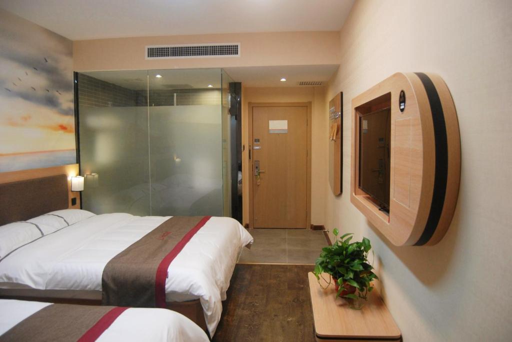 a hotel room with two beds and a glass door at Thank Inn Chain Hotel Hebei Baoding Wangdu County Bus Station in Baoding