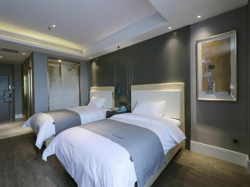 2 camas en una habitación de hotel con en Lano Hotel Kashgar Shache County Youyi West Road, en Shache