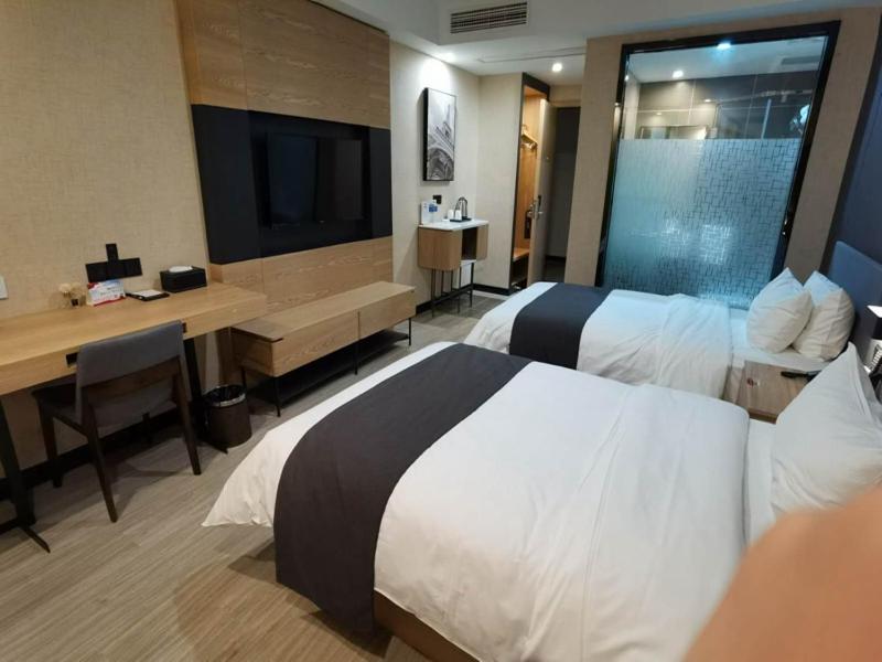 um quarto de hotel com duas camas e uma secretária e uma televisão em Up And In Jiangsu Nanjing Jiangning District Guli Town Government Store em Nanquim