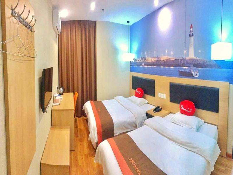 a hotel room with two beds with red hats on them at JUN Hotels ujian Fuzhou Jinan District Railway Station in Fuzhou