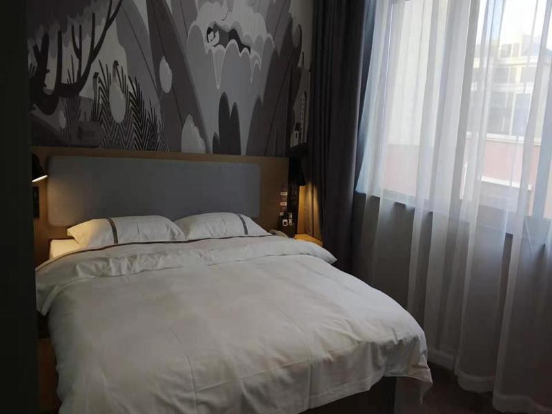 a bedroom with a large white bed with a window at Thank Inn Chain Hotel Anhui Suzhou Lingbi County People's Hospital Zhongxiu Jincheng in Suzhou