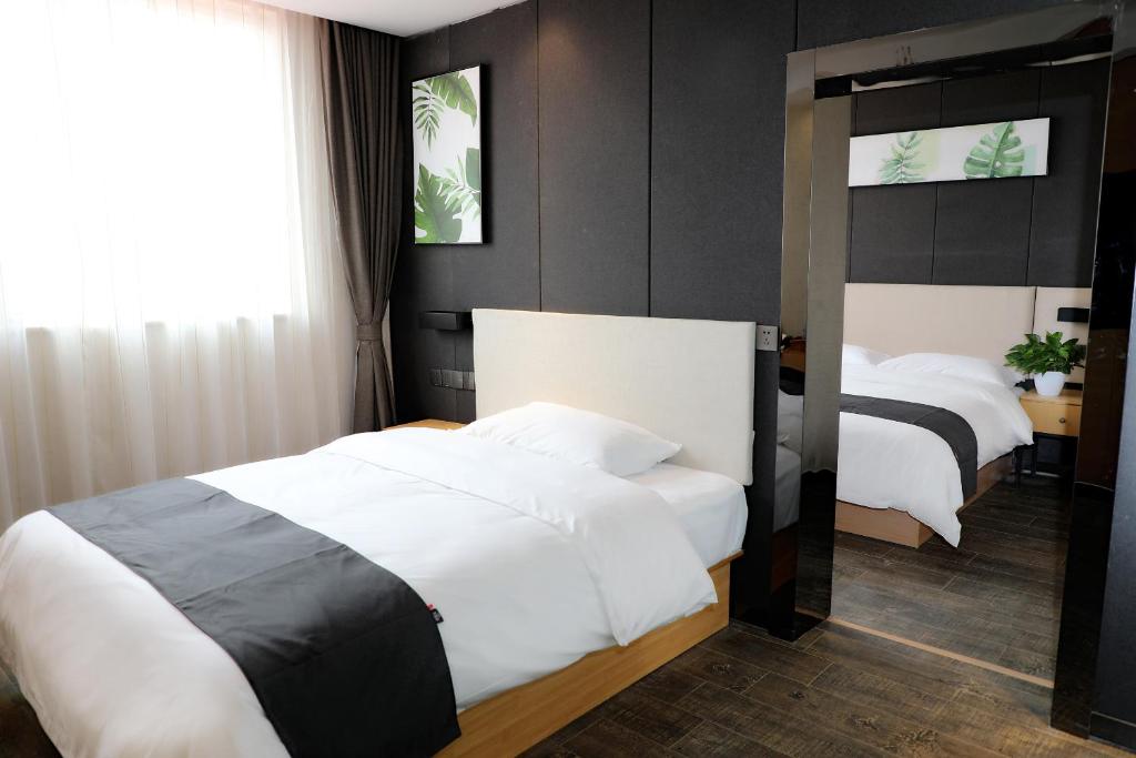 a hotel room with two beds and a mirror at Thank Inn Chain Hotel Shandong Linyi Junan County Longshan Road in Linyi