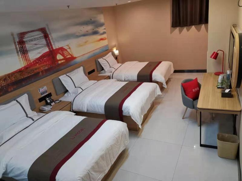 a hotel room with two beds and a desk at Thank Inn Chain Hotel Aksu Juche Tianwu Plaza in Kuqa