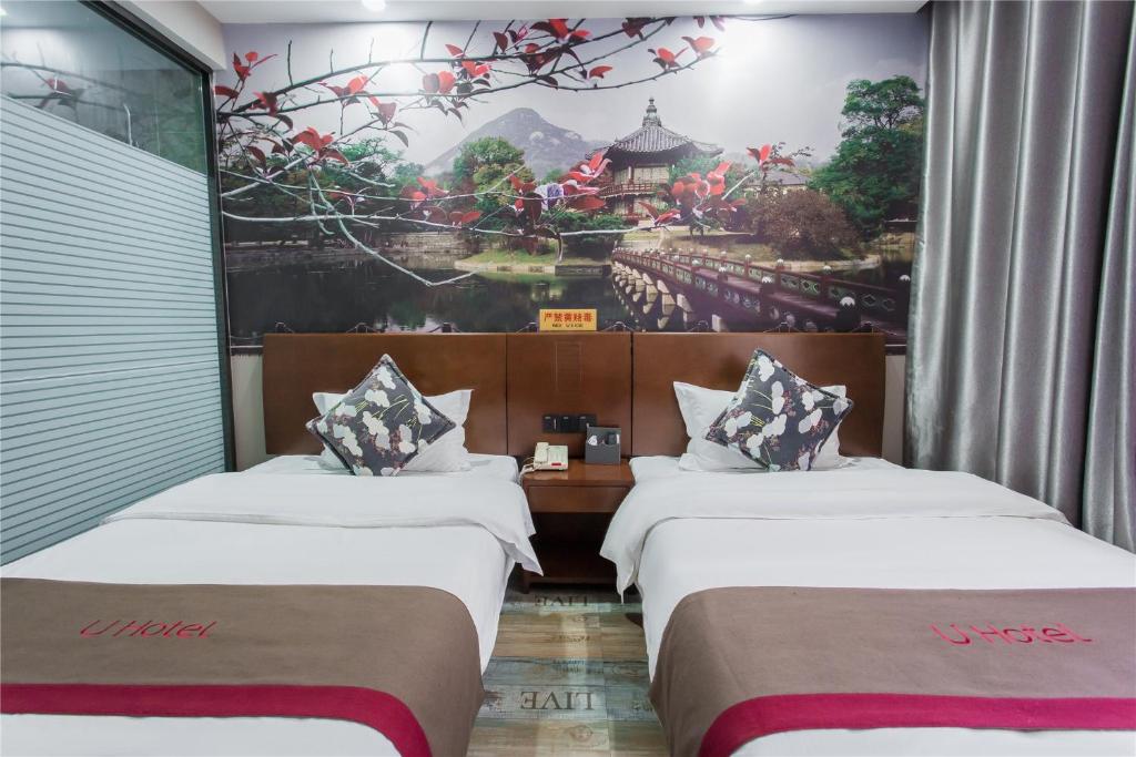 two beds in a room with a painting on the wall at Thank Inn Chain Hotel Shanxi Taiyuan Wanbolin District Wanxiang City in Taiyuan