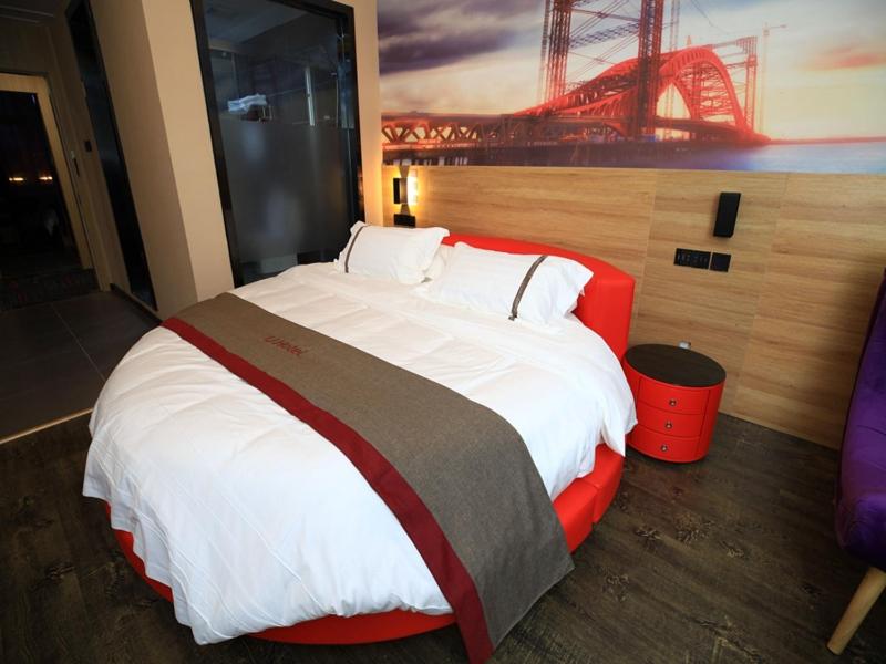 um quarto com uma cama grande e uma cabeceira vermelha em Thank Inn Chain Hotel Anhui Bengbu Huaiyuan County Huarun Suguo Store em Wuchazhen