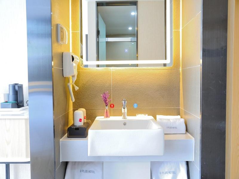 a bathroom with a white sink and a mirror at Up And In Rizhao Wulian County Wulian Square in Rizhao