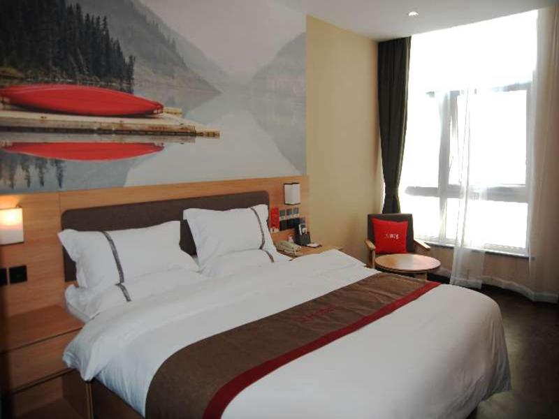 a bedroom with a large bed and a large window at Thank Inn Chain Hotel Tianjing Jingnan District Balitai Town Industrial Park in Tianjin
