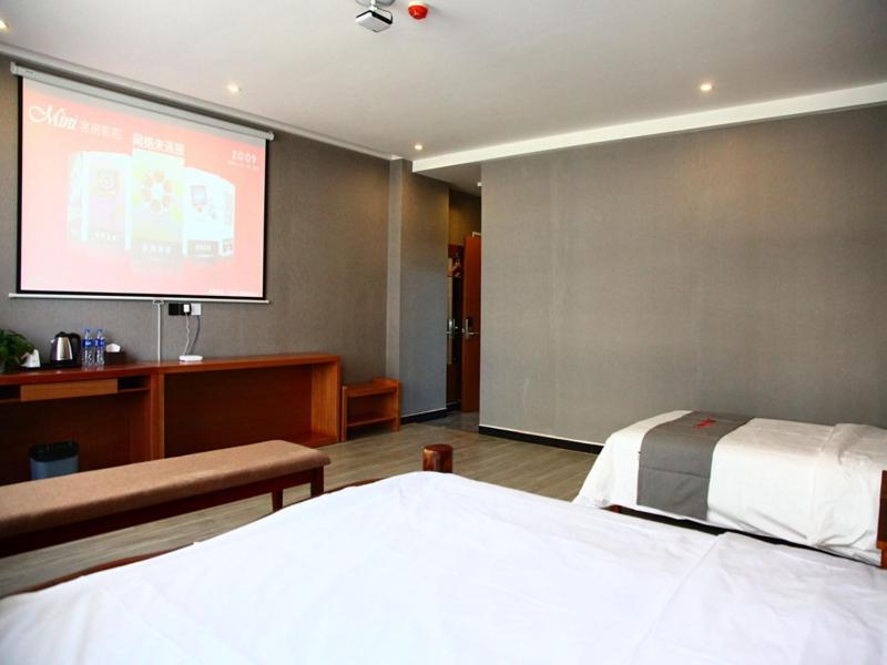 a room with a bed and a projection screen at JUN Hotels Hebei Hengshui Gucheng County Yingrui Plaza in Hengshui