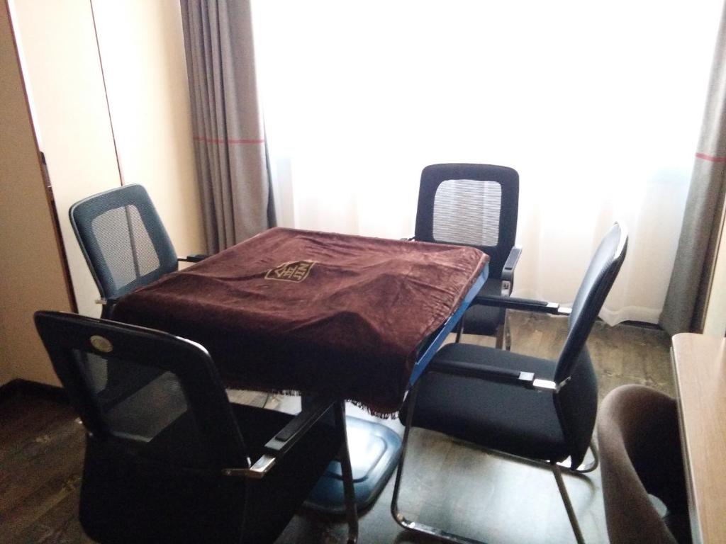- une table avec une couverture dans une chambre dans l'établissement Thank Inn Plus Hotel Handan Wei County Xianbiao, à Handan