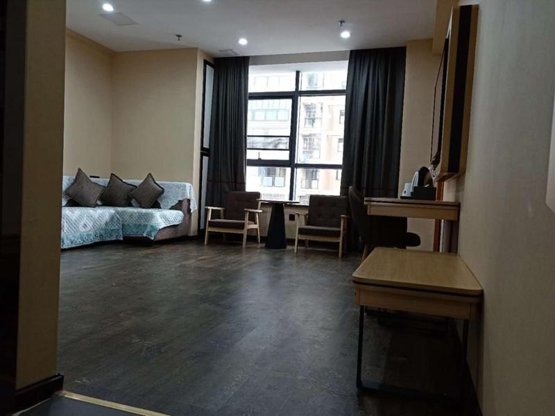 sala de estar con cama y ventana en Thank Inn Plus Hotel Guizhou Zunyi Suiyang County Shixiang Avenue, en Zunyi