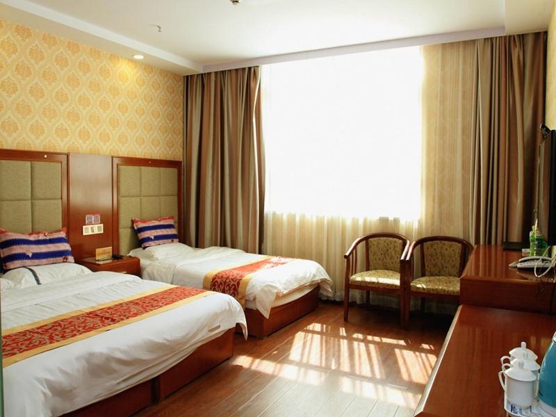 a hotel room with two beds and a window at JUN Hotels Zhangjiakou Qiaodong District Yu'er Mountain Taihe Home in Zhangjiakou