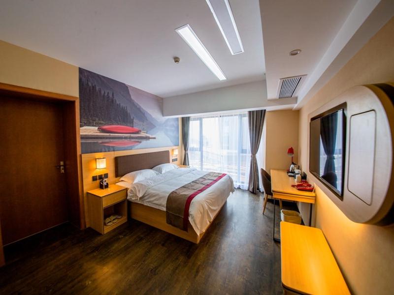 Habitación de hotel con cama y TV en Thank Inn Chain Hotel Shandong Linyi Lanshan District Liguan Town, en Linyi